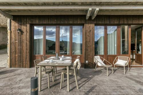 a wooden table and chairs on a patio at La Cabanya de La Rovira in Joanetes