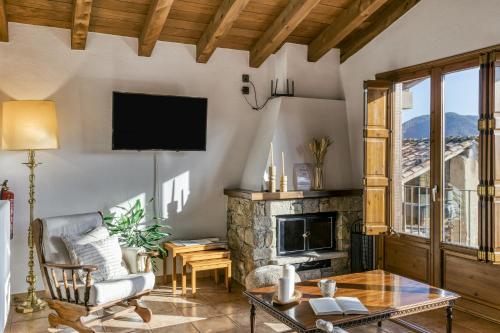 a living room with a fireplace and a tv at La Cabanya de la Rovira - Dalt in Joanetes