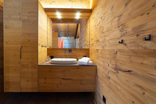 a bathroom with a sink in a wooden wall at Chalet Schibenstoll in Wildhaus