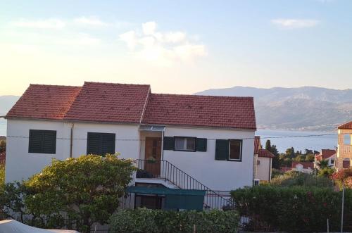 a white house with a red roof at Apartment Sani in Supetar