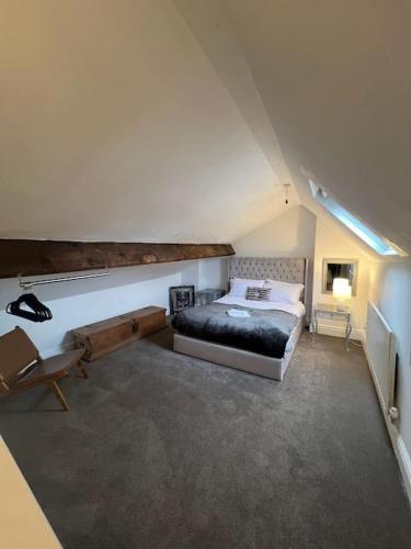 a attic bedroom with a bed and a chair at 6 bed house - 12 minutes to City Centre in Birmingham