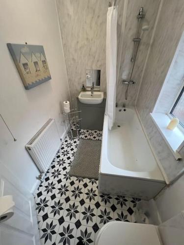 a bathroom with a tub and a toilet and a sink at 6 bed house - 12 minutes to City Centre in Birmingham
