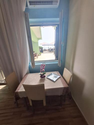 a table and chairs with a table and a window at Montesan Luxury Apartment Beach Front in Sveti Stefan