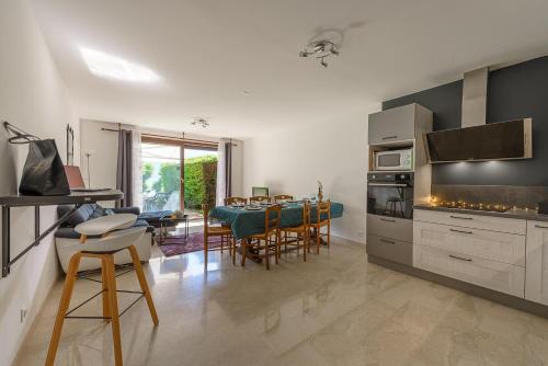 une cuisine et une salle à manger avec une table et des chaises dans l'établissement Cote Lac et Jardins acces direct au LAC ANNECY by LLA Selections, à Duingt