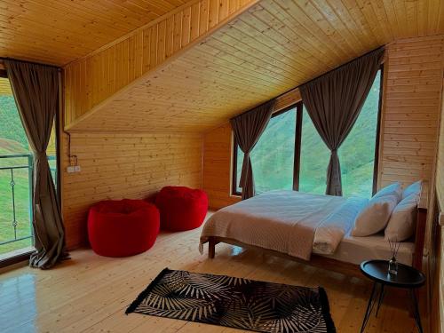 a bedroom with a bed in a room with windows at Rakursi in Jut'a