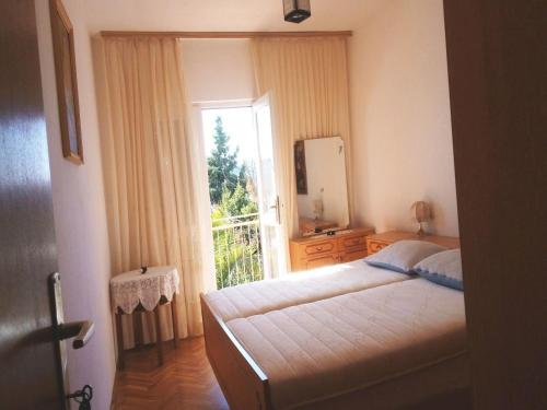 a bedroom with a bed and a mirror and a window at Apartments Ljubo in Stara Novalja