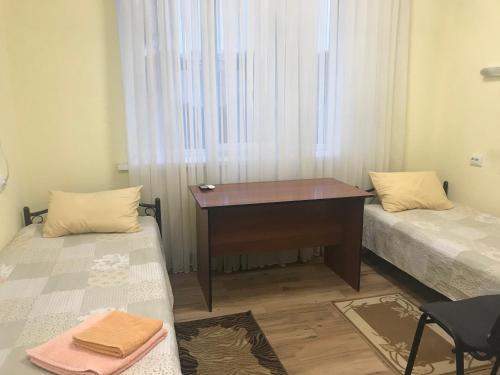 a desk in a room with two beds and a window at Karavella in Mykolaiv