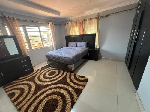 a bedroom with a bed and a rug at Lemajy Apartments - Flat 2 in Solwezi