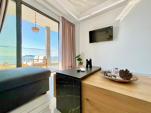 a living room with a couch and a tv with a view at Candi Luxury Suites 2 in Neos Marmaras