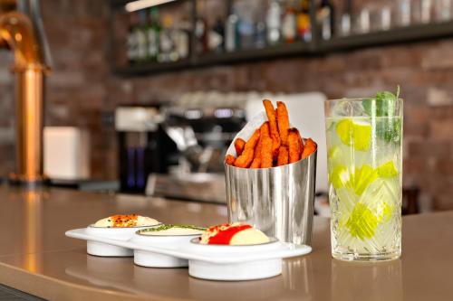 a plate of carrots and a drink on a counter at Holiday Inn Express Porto - Boavista by IHG in Porto