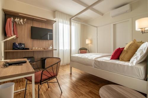 a hotel room with a bed and a table and a desk at Il Faro Luxury Rooms & Lounge in La Spezia
