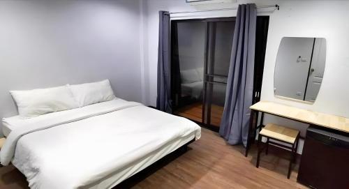 a bedroom with a white bed and a television at GO INN Chiang Mai University - CMU โกอินน์ มหาวิทยาลัยเชียงใหม่ in Chiang Mai