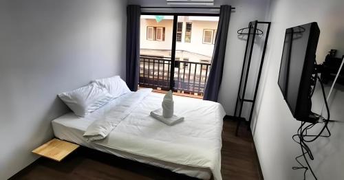 a room with a bed with a view of a balcony at GO INN Chiang Mai University - CMU โกอินน์ มหาวิทยาลัยเชียงใหม่ in Chiang Mai