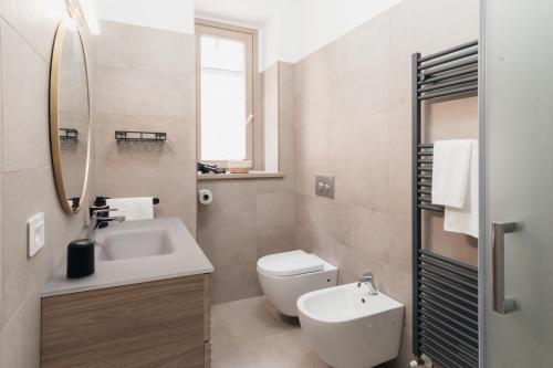 a bathroom with a sink and a toilet and a mirror at Via Roma 34 in Castiglione del Lago
