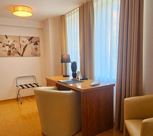 a office with a desk and a chair and a window at Ecoinn in Esslingen