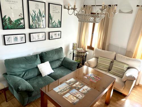 a living room with a green couch and a table at Suite El Alcázar in Carmona