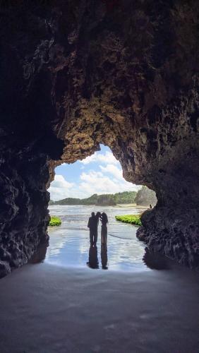 zwei Menschen stehen vor einer Höhle in der Unterkunft Tenda camping in Madasari