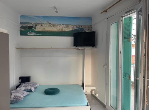 une chambre avec un lit, une télévision et une fenêtre dans l'établissement Stud terras Ville Corniche 2 pers stat gratuit rue Modif suivt possib et accord exclusif, à Marseille