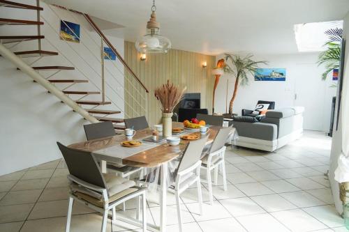 une salle à manger et un salon avec une table et des chaises dans l'établissement Charmante maison proche plages et GR34, à Perros
