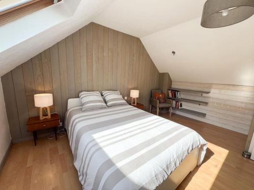 une chambre avec un grand lit avec deux oreillers dans l'établissement Charmante maison proche plages et GR34, à Perros