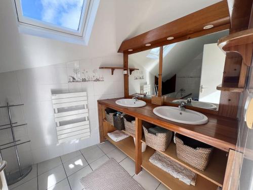 une salle de bain avec deux lavabos et un grand miroir dans l'établissement Charmante maison proche plages et GR34, à Perros