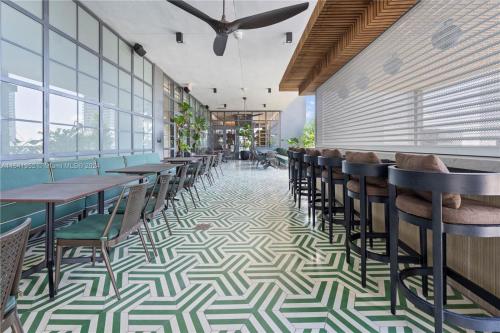 a restaurant with tables and chairs on a patterned floor at La Terrasse by VIAC - Luxury Bay View Studio with Balcony 29th Floor Miami in Miami