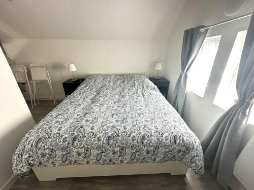 ein Schlafzimmer mit einem Bett mit Bettdecke und einem Fenster in der Unterkunft Residence Champenoise 5, Troyes - France in Troyes