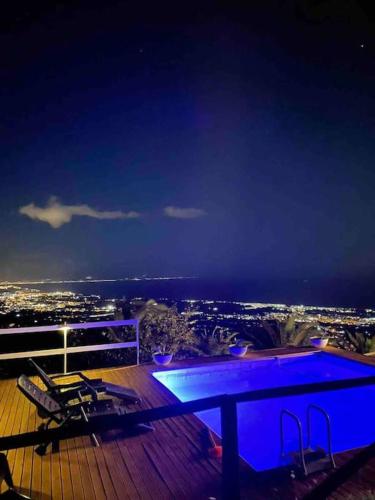 a table on a deck with a view of the city at Villa panoramica sull'Etna con piscina vista mare in Montargano