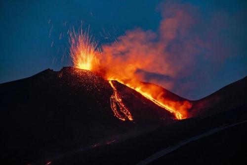 a mountain with a fire on top of it at night at Villa panoramica sull'Etna con piscina vista mare in Montargano