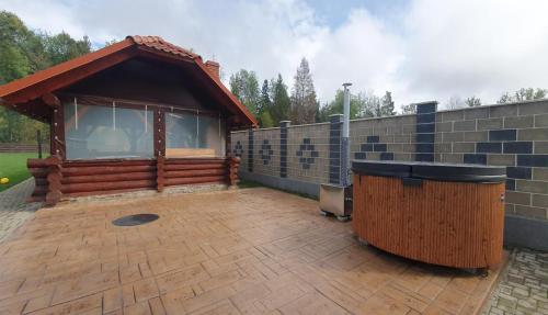 a wooden pavilion with a wooden barrel on a patio at Pensiunea Sofy Mar in Poiana Micului