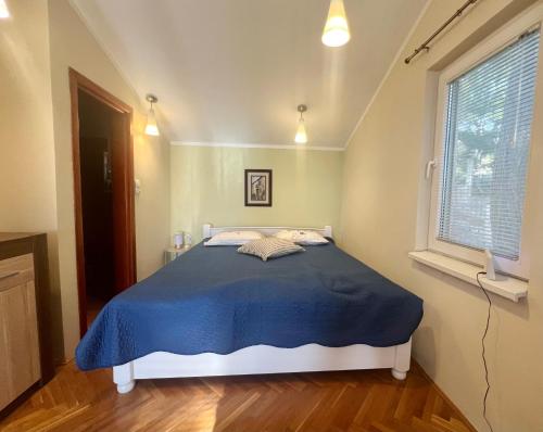 a bedroom with a bed with a blue blanket at Blue Sky Villa in Brca