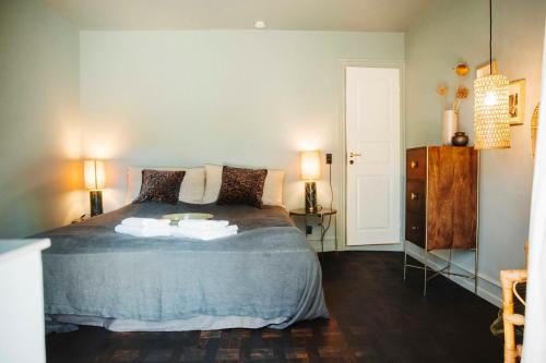 a bedroom with a bed with two lamps and a dresser at The Falcon Hotel in Allinge