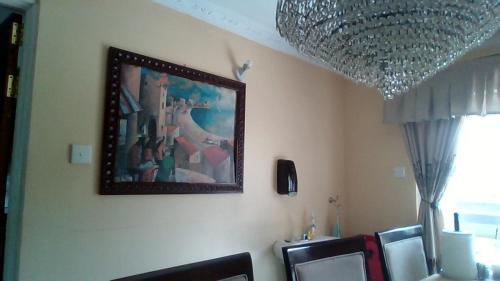 a dining room with a picture on the wall at Jo-Casa in Athi River