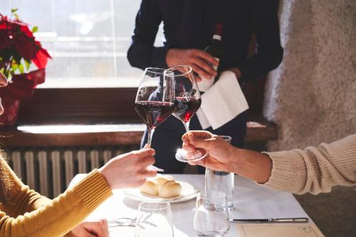 two people holding glasses of wine at a table at Forte Family Village - Azzurro Club in Sella Nevea