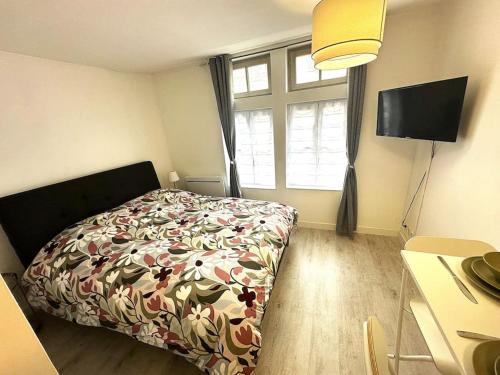 1 Schlafzimmer mit einem Bett mit Blumenbettdecke und einem Fenster in der Unterkunft Résidence Champenoise 3, Troyes - France in Troyes