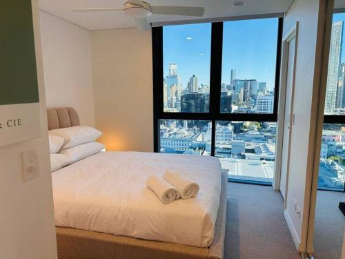 a bedroom with a white bed and a large window at Utopia City Oasis Exquisite Urban Retreat in Brisbane