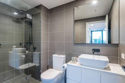 a bathroom with a toilet and a sink and a mirror at Utopia City Oasis Exquisite Urban Retreat in Brisbane