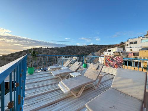 塔哈佐特Jada surf house taghazout的木甲板上一排躺椅