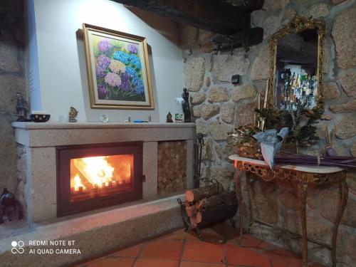 a fireplace in a room with a stone wall at Casa da Garrida in Vitorino das Donas