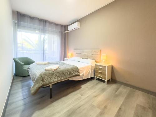 a bedroom with a bed and a chair and a window at Bga rentals Punta Prima in La Pineda