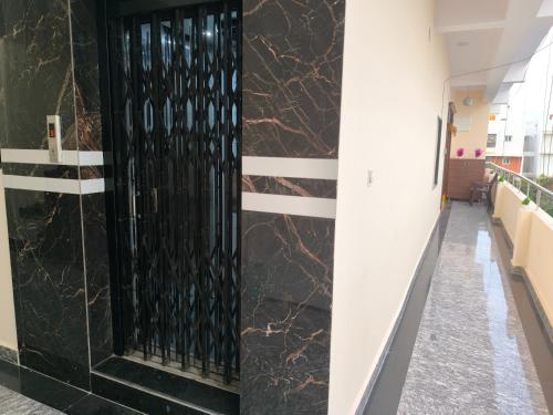 a hallway with a black door in a building at Orraica Stays Vajra Rao Luxe in Gundipet