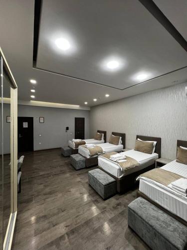 a room with four beds and couches in it at Shosh Palace in Tashkent