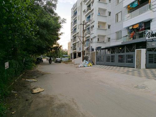 an empty street in front of a tall building at Orraica Stays Vajra Rao Luxe in Gundipet