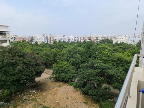 a bunch of trees with buildings in the background at Orraica Stays Vajra Rao Luxe in Gundipet