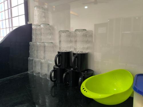 a bathroom with a green bowl and glass vases at Orraica Stays Vajra Rao Luxe in Gundipet