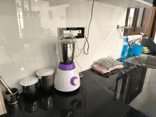 a blender sitting on a counter next to a sink at Orraica Stays Vajra Rao Luxe in Gundipet