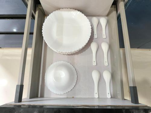 a box with white plates and utensils in it at Orraica Stays Vajra Rao Luxe in Gundipet