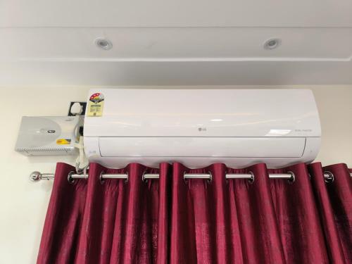 a sewing machine sitting on top of a curtain at Orraica Stays Vajra Rao Luxe in Gundipet