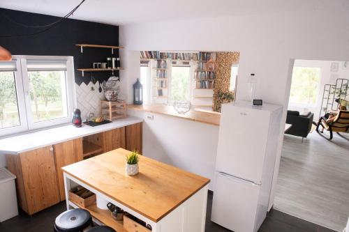 Il comprend une cuisine équipée d'un réfrigérateur blanc et d'une table en bois. dans l'établissement Family home, near therme/airport/ lake, Balotesti, à Căciulaţi