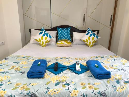 a bed with blue towels and pillows on it at Orraica Stays Vajra Rao Luxe in Gundipet